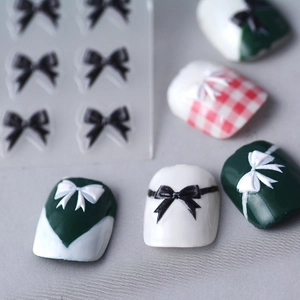 5D embossed nail stickers featuring black and white bows on various manicured nails
