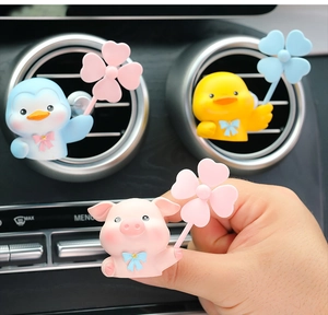 Close-up of cute penguin, duck and pig cartoon vent clips with pinwheels for car decor