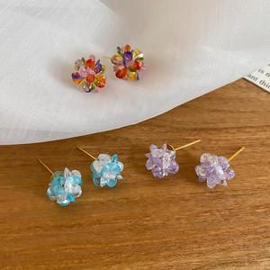 Detailed close-up of three pairs of colorful handmade crystal flower stud earrings