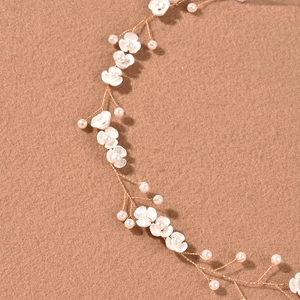 Elegant bridal headband with white handmade flowers and pearls on golden wire