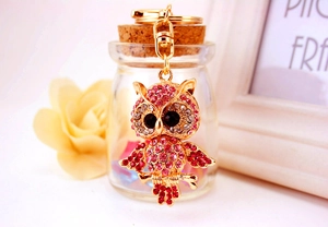 Close-up of golden owl keychain with pink rhinestones and a lobster clasp detail