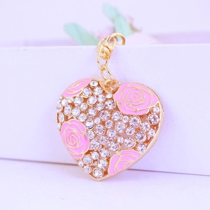 Porte-clés cœur doré avec roses en émail rose et cristaux brillants sur fond blanc