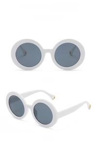 Close-up of white round sunglasses frame with dark lenses and metal hole temple detail