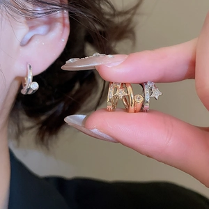Détail de boucles d'oreilles étoile plaquées or 18k en finitions argent, or et or rose