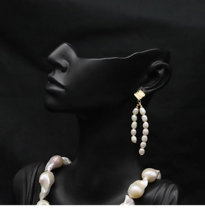 Elegant baroque pearl necklace and earring set displayed on a professional black model bust