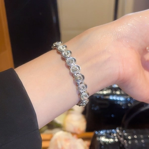 Close-up of a sparkling silver tennis bracelet with round rhinestones on a woman's wrist