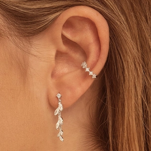 Macro shot of silver crystal leaf drop earring and ear cuff with marquise zircons