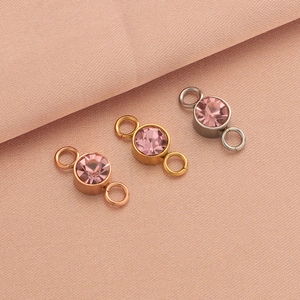 Detailed view of rose gold, gold, and silver double charms with pink birthstone crystals