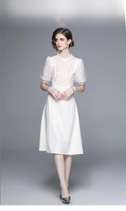 Détail des manches bouffantes blanches et broderie dentelle en cœur sur la robe