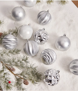 Detailed view of silver and white Christmas ornaments with pine needles and snowy texture
