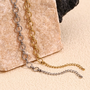 Detail of 14K gold and silver plated stainless steel chain anklets on a pink stone