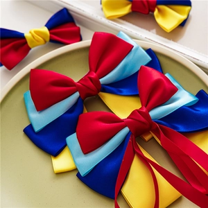 Detail of multi-layered colorful satin ribbon bow hair clip in red, yellow and blue