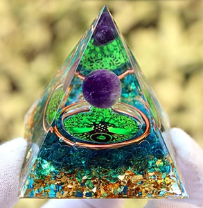 Detail of Orgone Pyramid with tree of life symbol, amethyst ball, and natural crystals