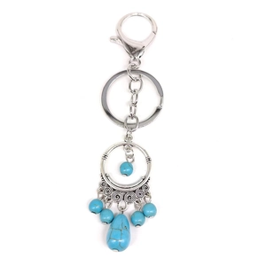 Detail of bohemian silver keychain with turquoise beads and ethnic vintage design