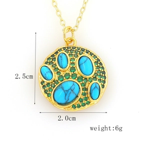 Detail view of 2.5cm gold paw pendant with teal marbled stone and green crystals