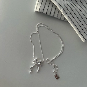 Detail of 925 sterling silver bow pendant showing the polished finish and logo tag