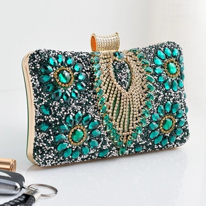 Detail of evening clutch featuring emerald floral rhinestones and gold metal frame