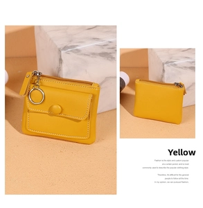 Detail view of a yellow compact leather coin purse with metal zipper and key ring