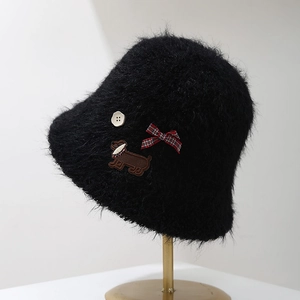 Détail du chapeau cloche en peluche noire avec patch de chien et nœud à carreaux
