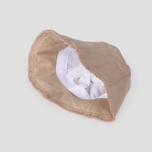 Internal view of beige corduroy bucket hat with cotton lining and care label detail