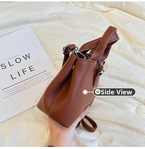 Vue latérale du sac en cuir marron grainé avec boucle argentée et détails raffinés