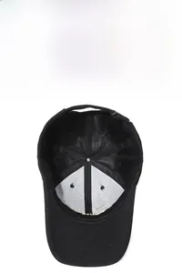 Detail of black baseball cap interior with gold letter embroidery and adjustable metal buckle