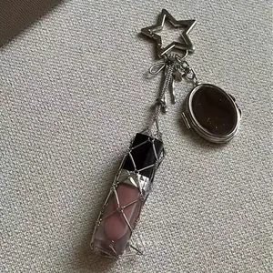 Close-up of pink lip glaze charm with silver metal mesh, star clasp and mini mirror
