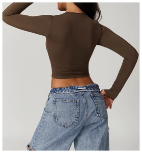 Close-up back view of tight long-sleeve crop top with distressed wide-leg jeans