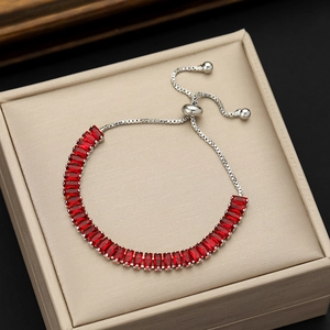 Detail of red rectangular zircon bracelet with adjustable silver slider clasp on jewelry box