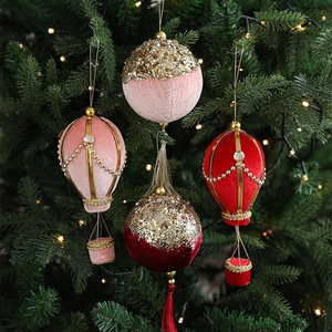 Velvet hot air balloon and glittery ball ornaments on a decorated Christmas tree
