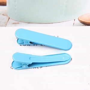 Close-up of blue candy-colored metal duckbill hair clips with a smooth painted finish