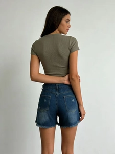 Détails d'un short en jean taille haute avec bords effilochés et ourlet brut au dos