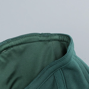Vue macro du tissu en maille côtelée vert foncé montrant les coutures et la texture