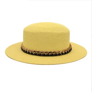 Texture détaillée du chapeau canotier en paille tressée avec chaîne dorée et ruban noir