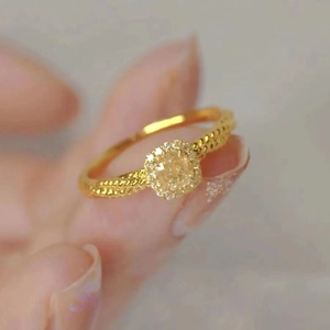 Anello con citrino quadrato, fascia dorata intrecciata e contorno di zirconi