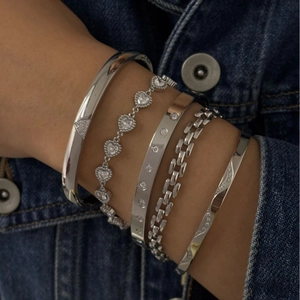 Ensemble de cinq bracelets en acier inoxydable argenté avec zircon sur du denim