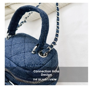 Detail of metal reinforced eyelet and silver chain on blue quilted denim crossbody bag