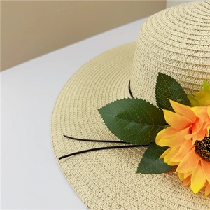 Vue détaillée de la texture du chapeau de paille avec grande fleur de tournesol et feuilles