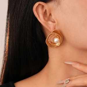 Detail of vintage gold rose petal earrings with pearl center and matching ring on model