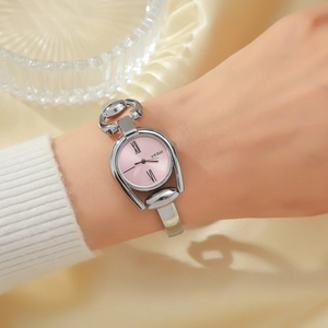 Detail of a vintage-style silver metal horsebit watch with a pink dial on a silk background
