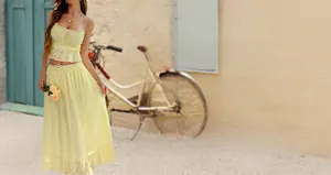 Detail of elegant yellow two-piece summer set with halter crop top and long skirt