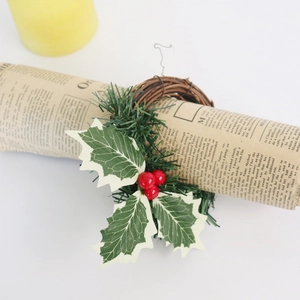 Détail du rond de serviette de Noël avec baies rouges et feuilles de houx vertes
