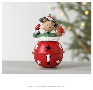 Detail of red metal Christmas bell with a cute cartoon reindeer topper for holiday decor
