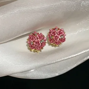 Pink rose flower earrings with clear rhinestones on elegant white silk background