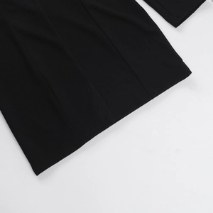 Gros plan sur la texture du tissu noir et les coutures propres de l'ourlet