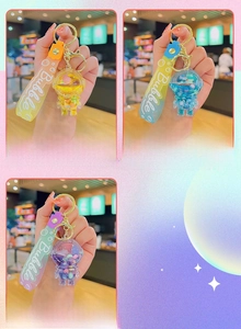 Close-up of astronaut liquid sand keychains in yellow, blue, and purple styles