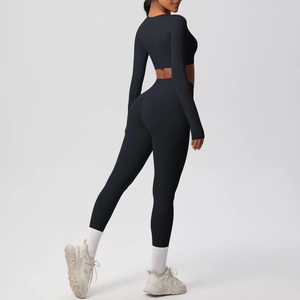 Detail view showing fit of black high-waist leggings and long-sleeve crop top yoga set