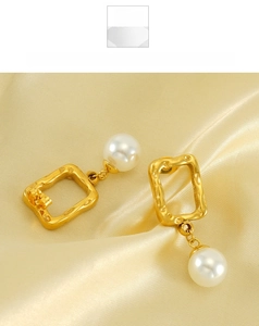 Detailed macro view of gold irregular rectangle hoop earrings with white round pearl charm