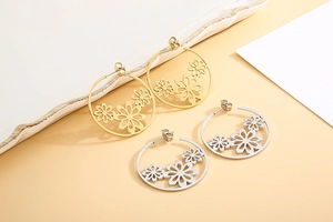 Detail showing floral hollow cut-out design on large gold and silver hoop earrings