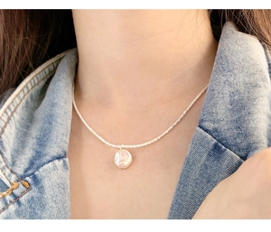 Close-up of a natural Baroque pearl pendant on a S925 sterling silver shimmering chain